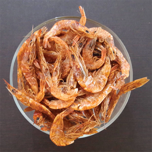 dried prawns Dried shrimp in a bowl on a wooden surface, showing their orange color and curled shapes